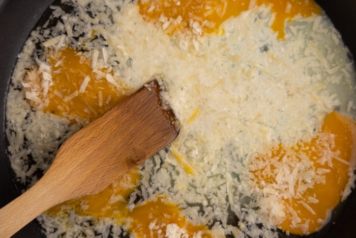 Faire des œufs brouillés avec du parmesan râpé