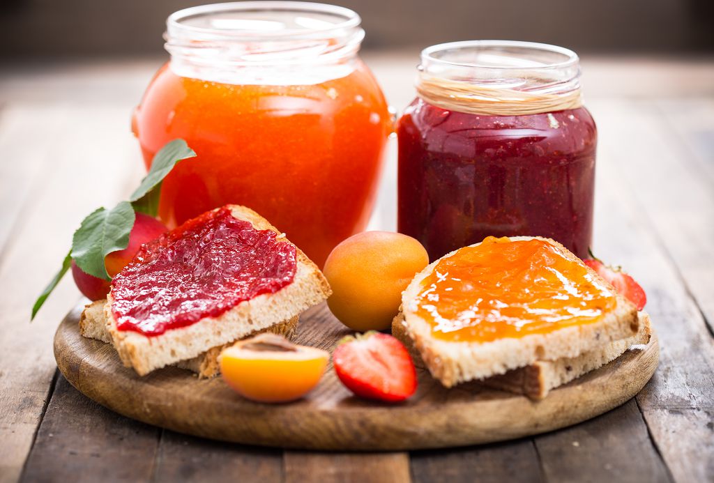 bouteilles de Freeze Jam, fruits et pain sur la planche à découper