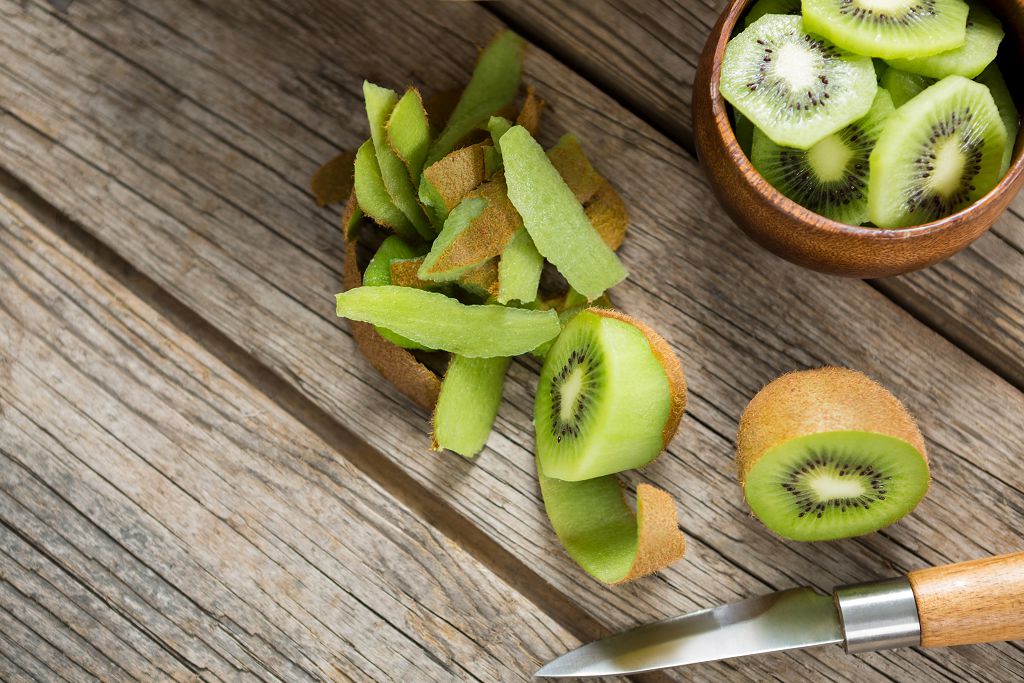 un bol de tranches de kiwi, des tranches de kiwi et un couteau