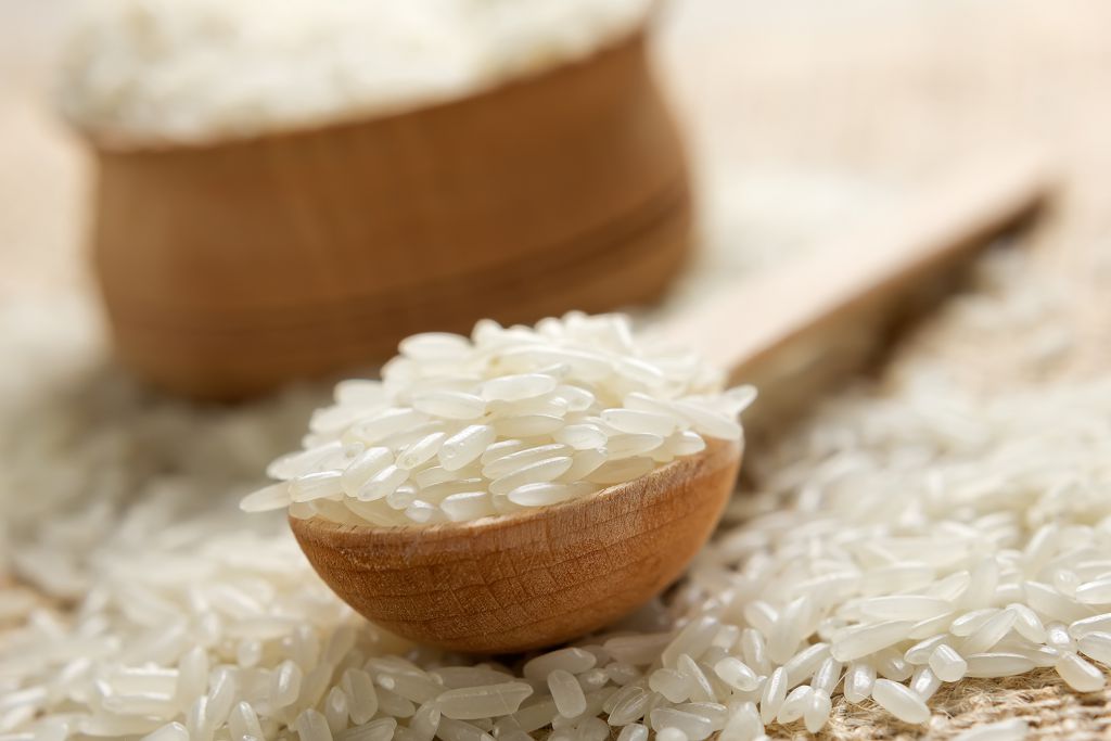 Un bol de riz non cuit et une cuillerée de riz non cuit