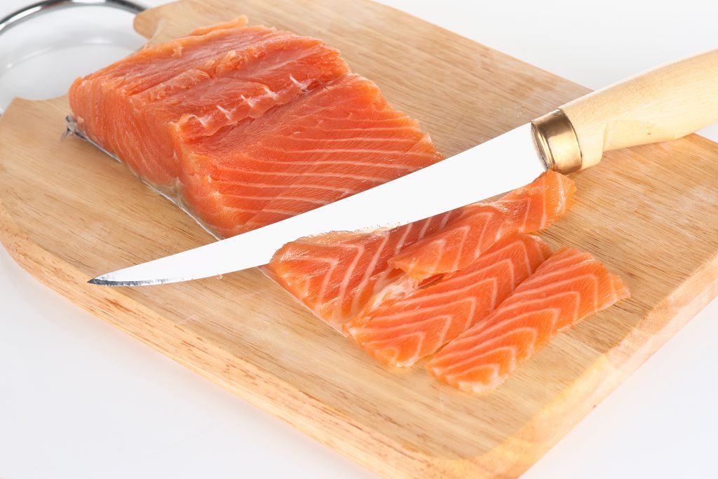 tranches de saumon et un couteau sur la planche à découper