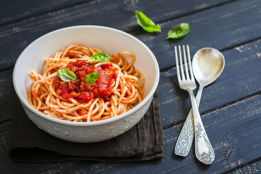 Un bol de spaghetti, une cuillère et une fourchette sur la table