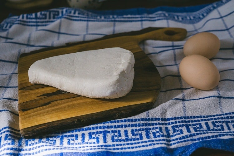  Fromage cottage sur la planche à découper et les œufs