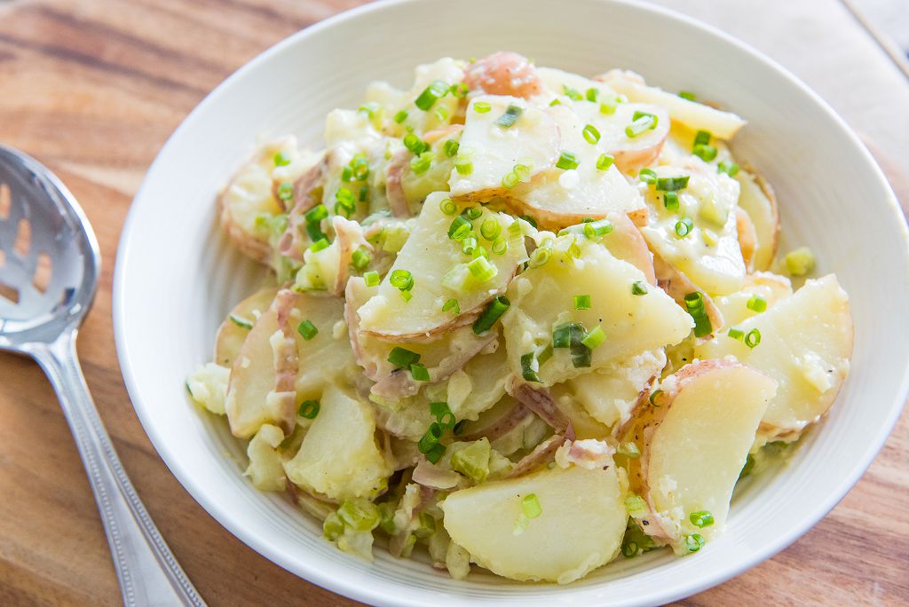Une assiette de salade de pommes de terre et une fourchette sur la table